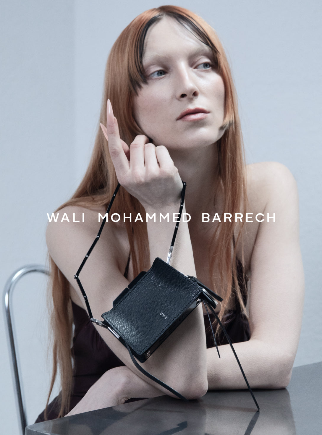 Woman holding a handbag with 'Wali Mohammed Barrech' branding Micro Frame - Petrol - WALI MOHAMMED BARRECH - Handcrafted Leather Handbags